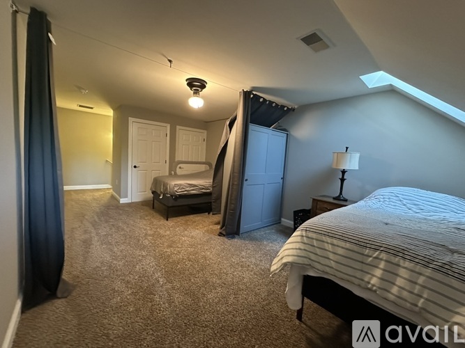 A bedroom with a bed, dresser, and nightstand.