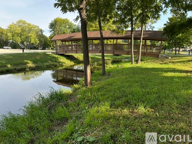 A gazebo sits in the middle of a grassy area next to a body of water.