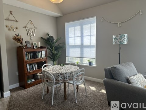 A living room with a dining table and chairs, a bookshelf, and a couch.