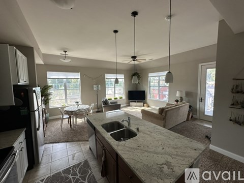 A kitchen with granite countertops and a dining area with a table and chairs.