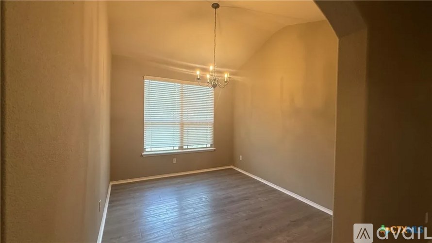 A room with a window and a chandelier.
