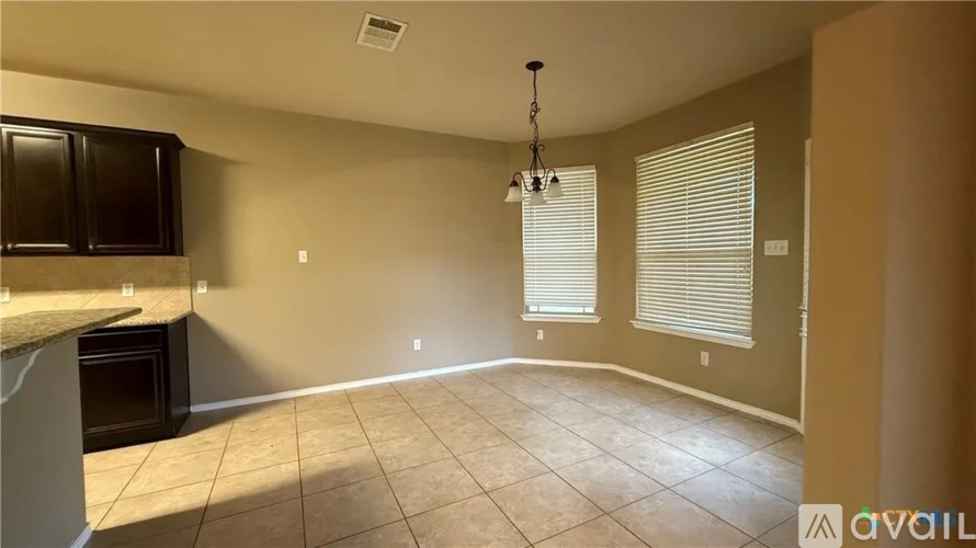 A room with a kitchen area and a large empty space.