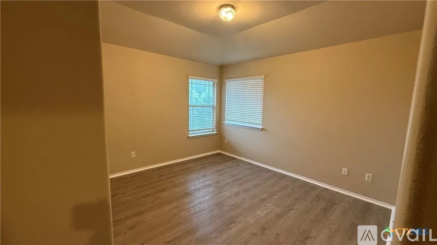 A room with a window and wooden flooring.