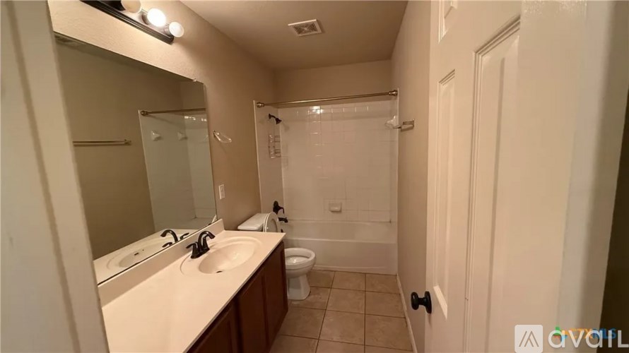 A bathroom with a sink, mirror, toilet, and shower.