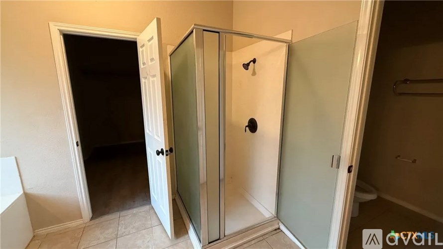 A bathroom with a toilet, sink, and shower stall.