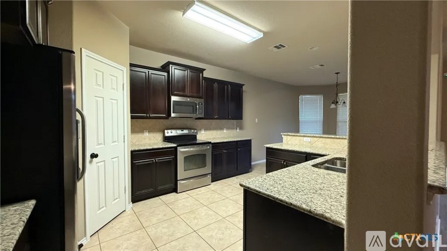 A kitchen with a black refrigerator and a white door.