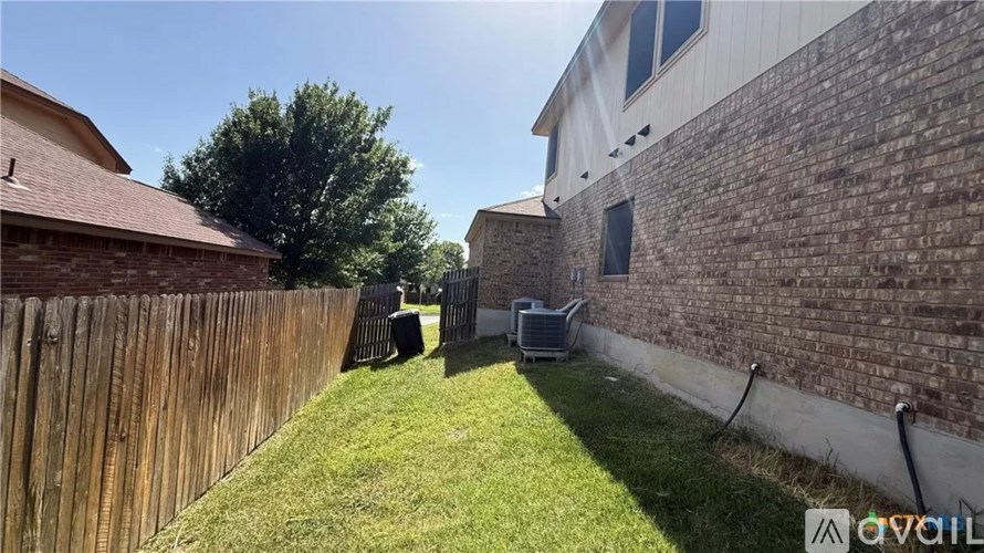 A backyard with a wooden fence and a grassy area.