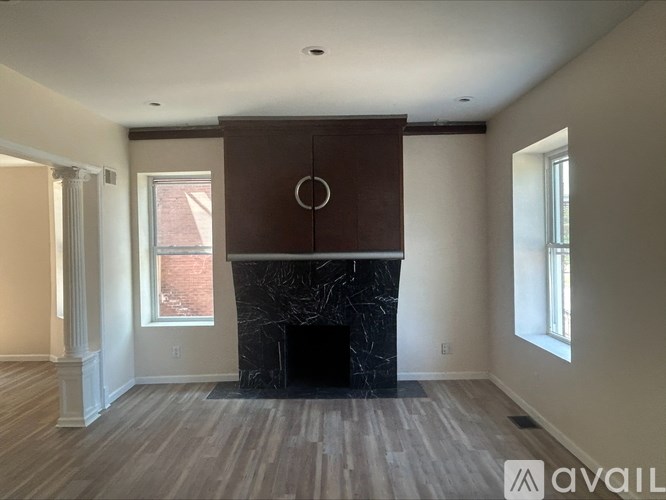 A living room with a fireplace and wood flooring.