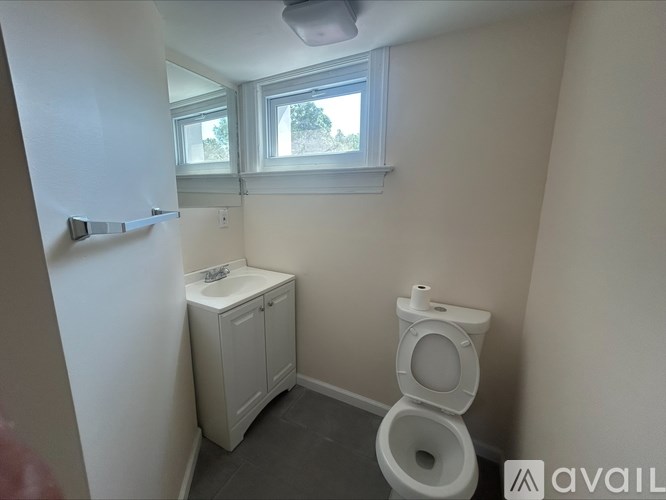 A small bathroom with a toilet and a cabinet.