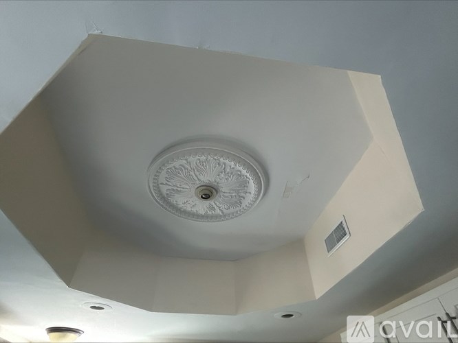 A white ceiling with a circular design in the middle.