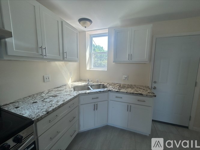 A kitchen with granite countertops and white cabinets.