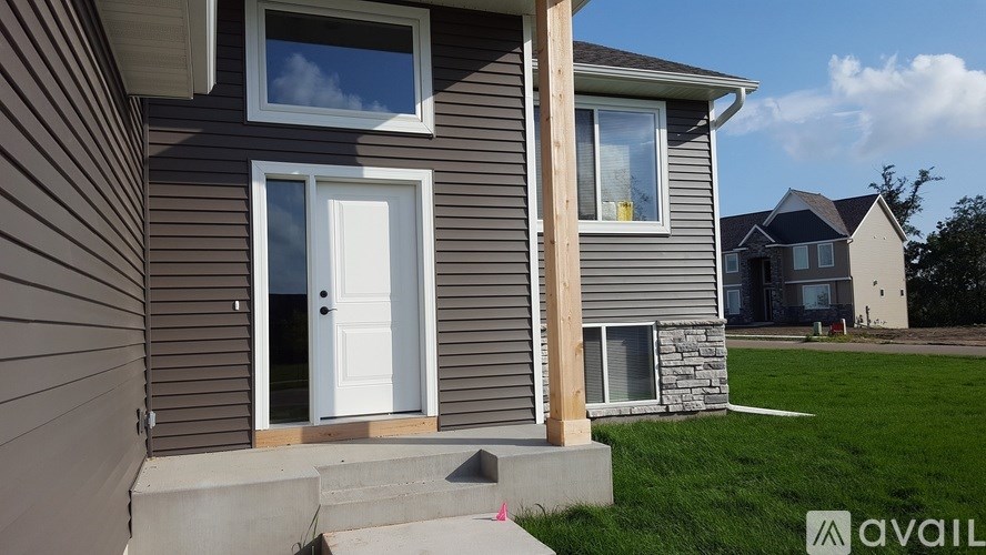 A house with a white door and a window with a view of the sky.
