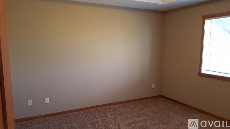 A room with a window and carpeted floor.