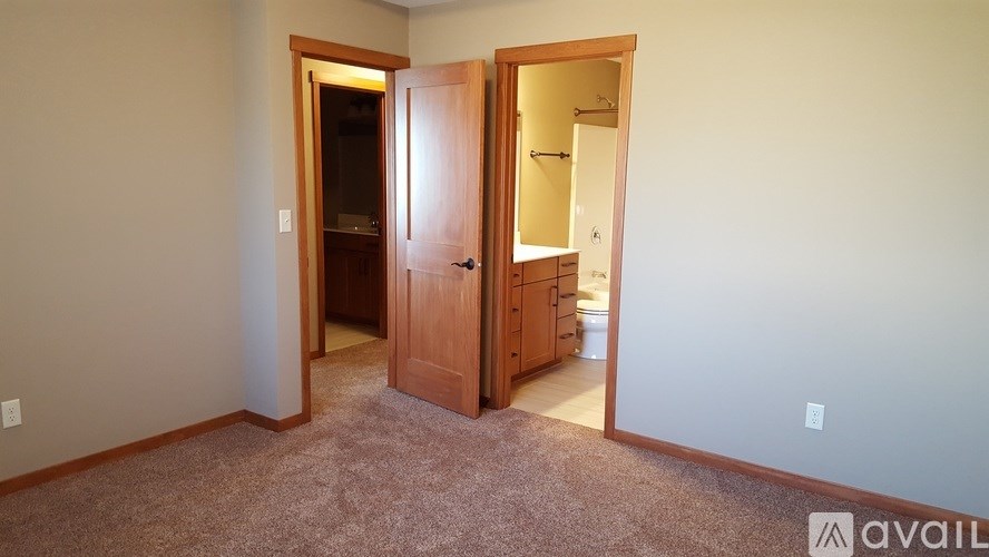 A room with a carpeted floor and a wooden door.