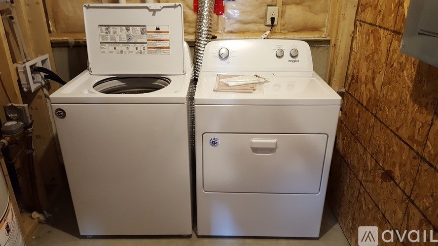 A white dishwasher and dryer are sitting next to each other.