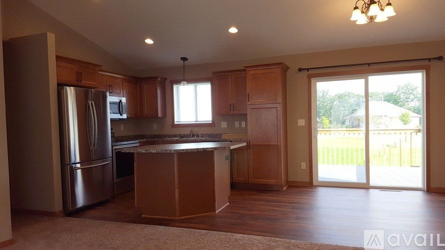 A kitchen with wooden cabinets and a stainless steel refrigerator.