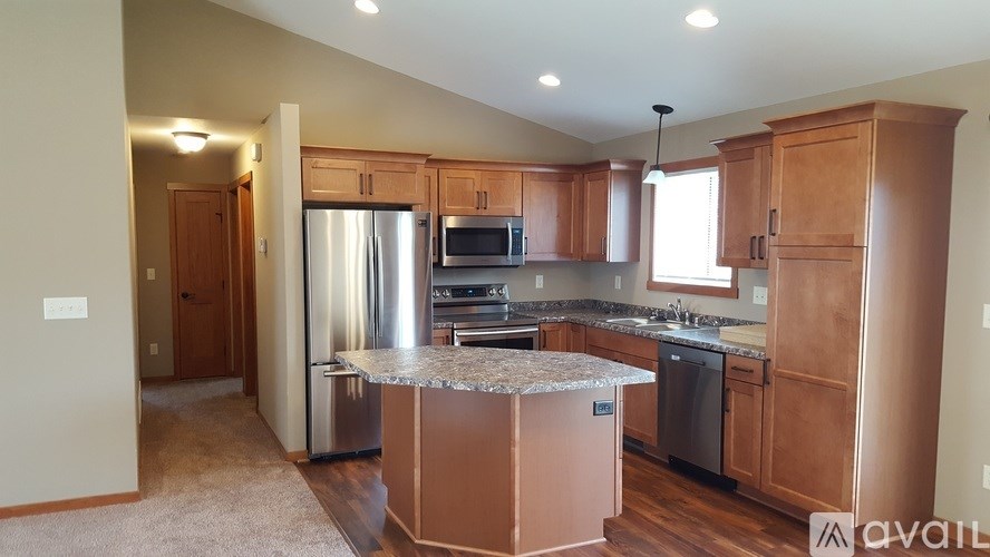 A kitchen with wooden cabinets and a granite countertop.