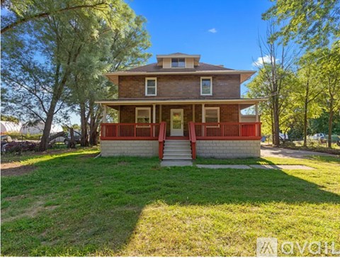 A house with a red front porch is for sale.