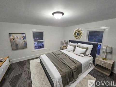 A bedroom with a large bed, a nightstand, and a painting on the wall.