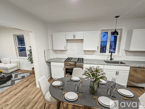 A modern kitchen with a dining table set for two.