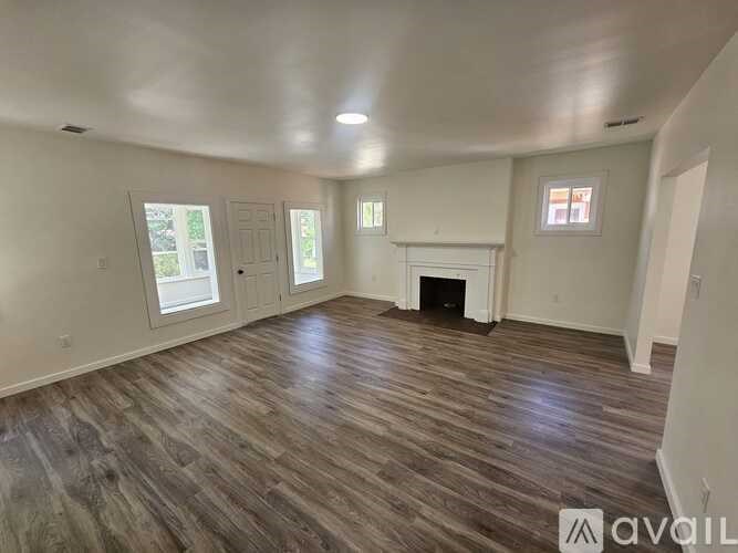 A room with wood flooring and a fireplace is available for rent.