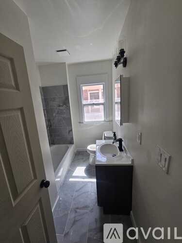 A bathroom with a sink, mirror, and a window.