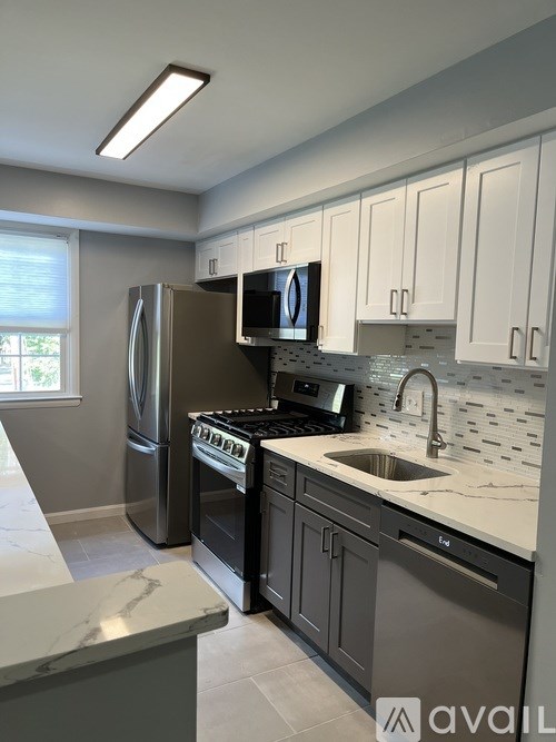 A kitchen with a refrigerator, oven, and microwave.