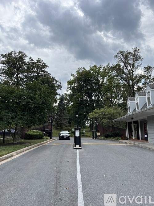 A street with a car parked on the side and a building in the background.