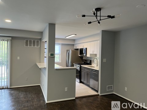 A modern kitchen with a stainless steel refrigerator and a dining area with a table and chairs.