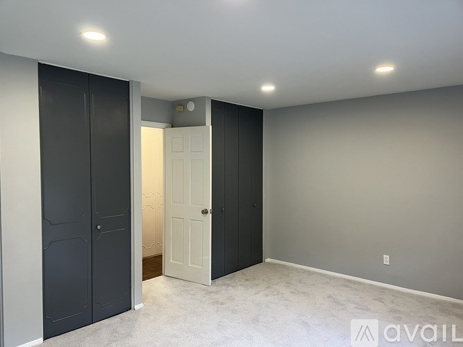 A room with a white door and a grey wall.