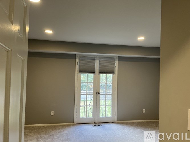 A room with a carpeted floor and a sliding glass door.