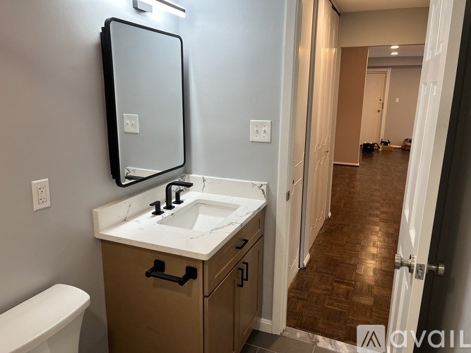 A bathroom with a sink, mirror, and toilet.