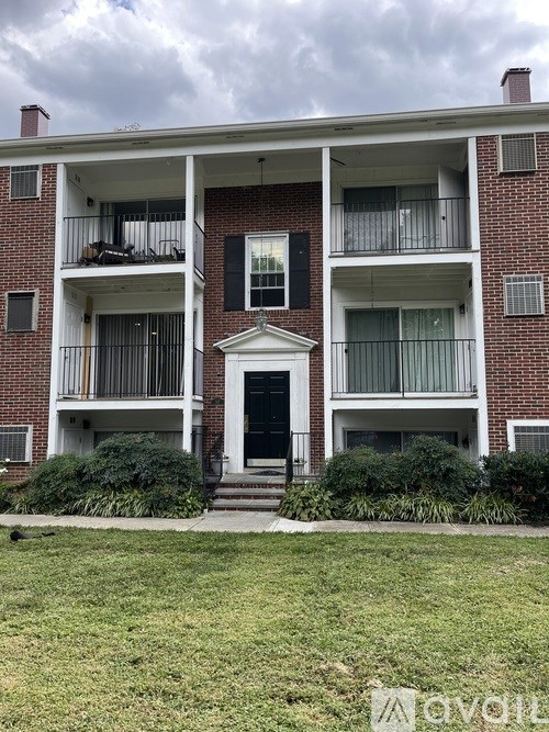 A red brick building with a white door and windows.