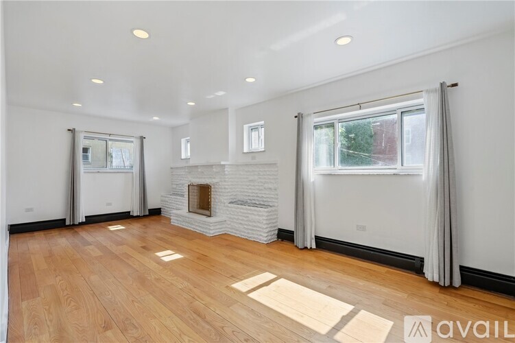 A spacious living room with a fireplace and hardwood floors.