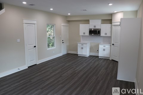 A kitchen with white cabinets and a microwave above the counter.