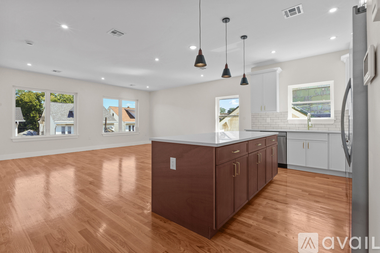 A kitchen with brown cabinets and a wooden floor.