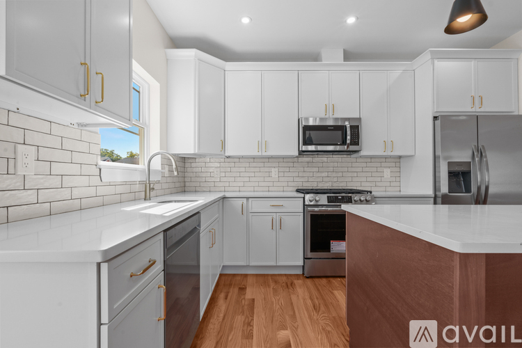A kitchen with white cabinets and a wooden floor.