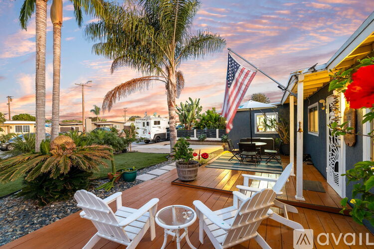 A wooden deck with two chairs and an American flag.