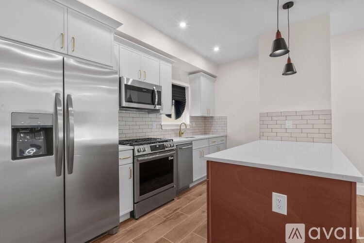 A kitchen with a refrigerator, oven, microwave, and stove.