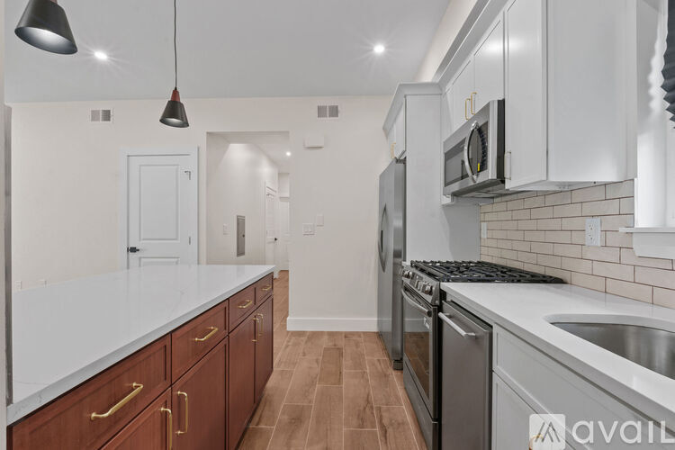 A kitchen with white cabinets and a wooden floor.