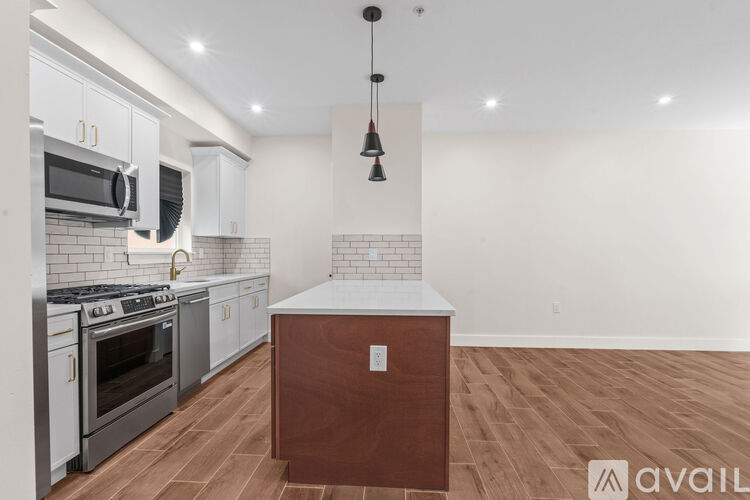 A kitchen with a white tile backsplash and a wooden island.