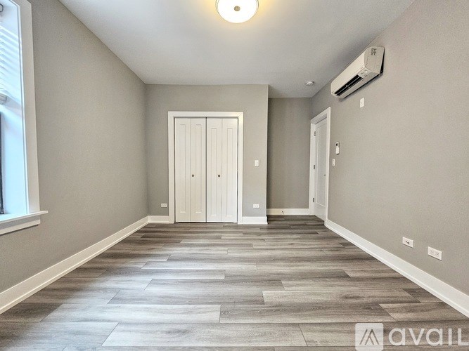 A spacious room with a wooden floor and a white door.