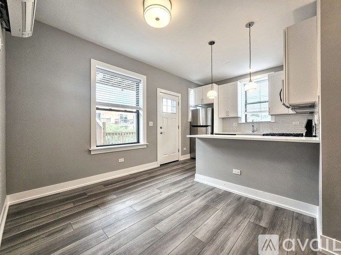 A kitchen with a grey floor and white walls.