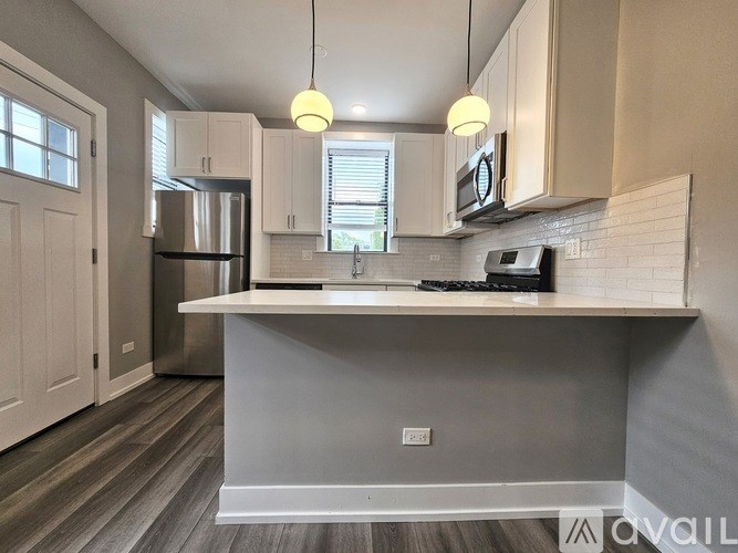 A kitchen with a refrigerator, microwave, and oven.