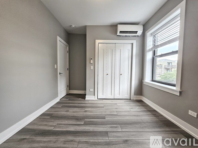 A room with a wooden floor and a white door.