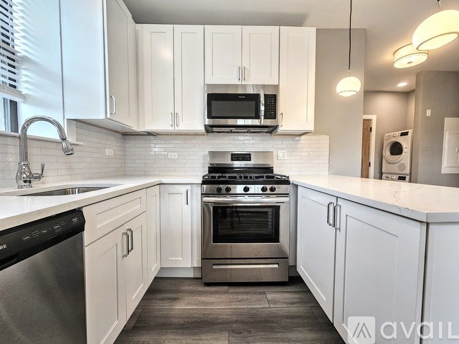 A modern kitchen with white cabinets and stainless steel appliances.