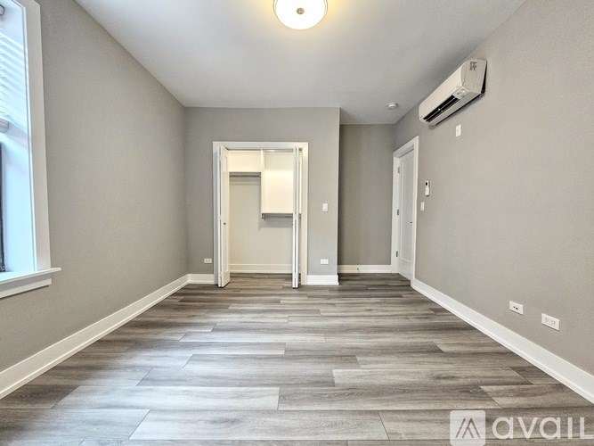 A spacious hallway with a tiled floor and an air conditioner mounted on the wall.