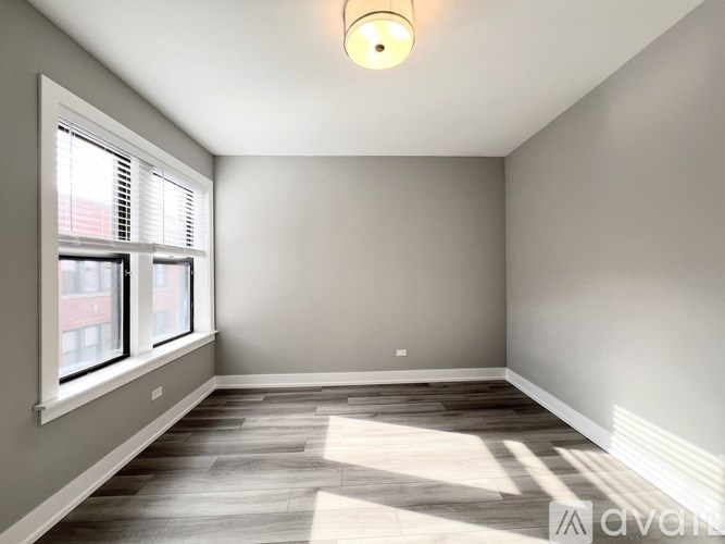 A room with a window and wooden flooring.