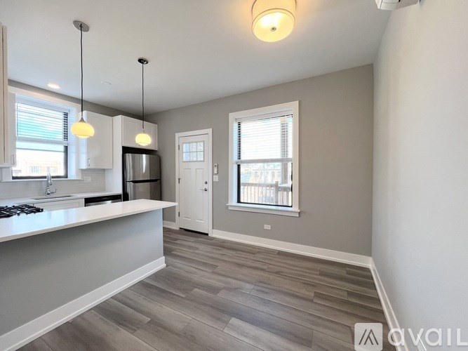 A kitchen with a white countertop and a window with blinds.