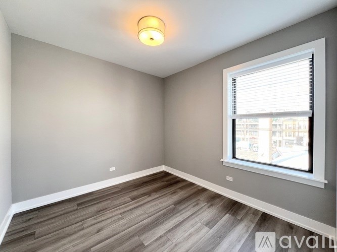 A room with a window and wooden flooring.